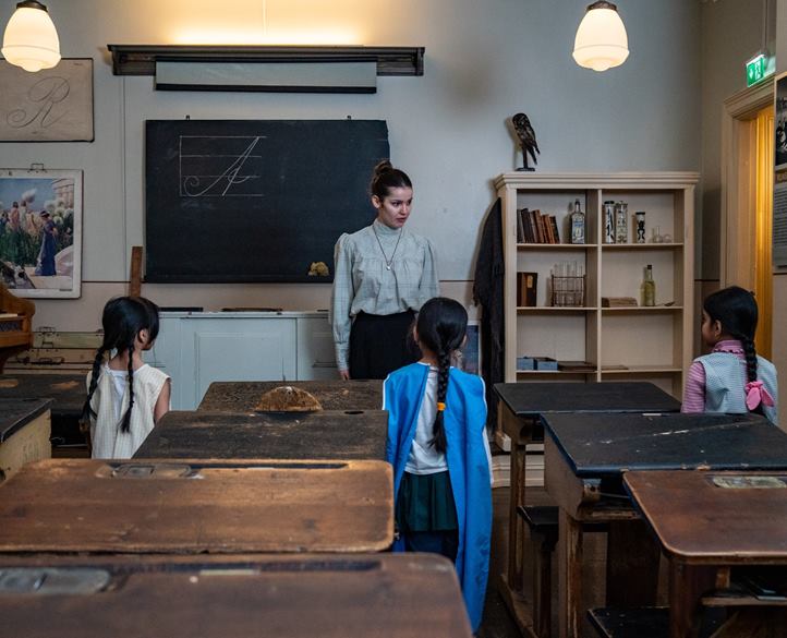 en person og noen få barn i et klasserom en person og noen få barn i et klasserom