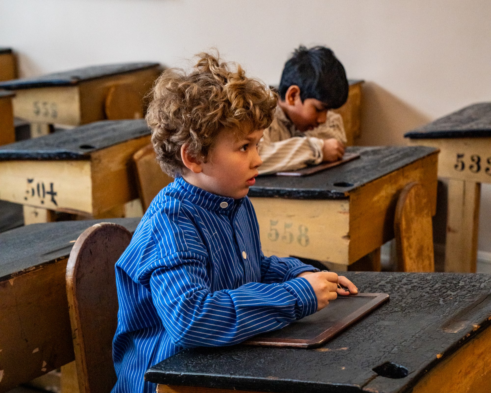 noen få barn sitter ved et skrivebord